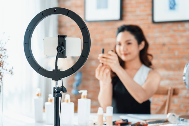 Asian Woman influencer shoot live streaming vlog video review makeup uttermost social media or blog. Happy young girl with cosmetics studio lighting for marketing recording session broadcasting online - Photo, Image