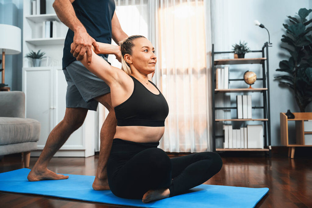 Happy active senior couple in sportswear being supportive and assist on yoga posture together at home. Healthy senior man and woman lifestyle with yoga exercise. Clout - Photo, Image
