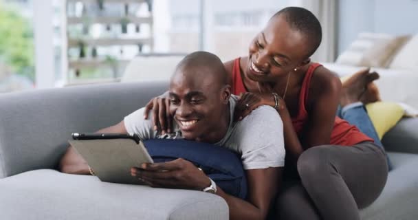 Αγάπη, χαλαρώστε και συνδυάστε με tablet σε έναν καναπέ για τα μέσα κοινωνικής δικτύωσης, chat ή web επικοινωνία στο σπίτι. Ψηφιακή, αναζήτηση και μαύροι αγκαλιάζουν σε ένα σαλόνι για online αγορές, εφαρμογές ή κρατήσεις διακοπών. - Πλάνα, βίντεο