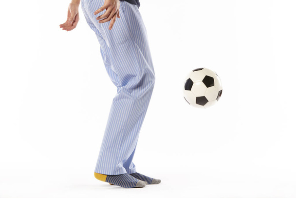 Pijamalı genç adam futbol oynuyor. Bacak detayı. Gece elbisesi - Fotoğraf, Görsel