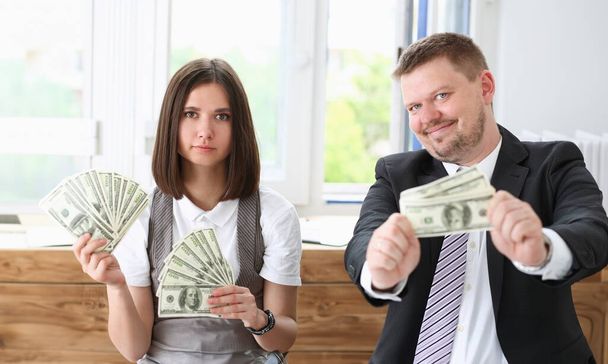 Muž a žena mají lehké peníze v podobě podvodů. Je demonstrovat v kameře a docela úsměv - Fotografie, Obrázek