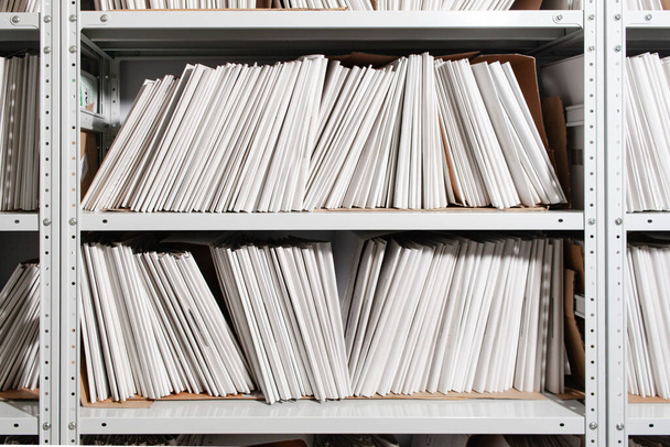 Regale mit Papierdokumenten. Organisierte Büroräume mit übersichtlich geordneten Papierdokumenten und Aktenschränken. - Foto, Bild