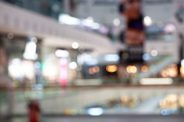 Rozmazaný pohled na rušný interiér nákupního centra s různými obchody a butiky, zachycující nákupní atmosféru na pulzujícím tržišti. - Fotografie, Obrázek