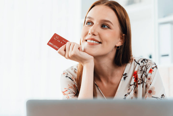 Νεαρή ευτυχισμένη γυναίκα αγοράζουν προϊόν με online αγορές στο σπίτι, ενώ η παραγγελία στοιχείων από το διαδίκτυο με πιστωτική κάρτα σε απευθείας σύνδεση σύστημα πληρωμών προστατεύεται από τη μέγιστη ασφάλεια στον κυβερνοχώρο από το ηλεκτρονικό κατάστημα πλατφόρμα - Φωτογραφία, εικόνα