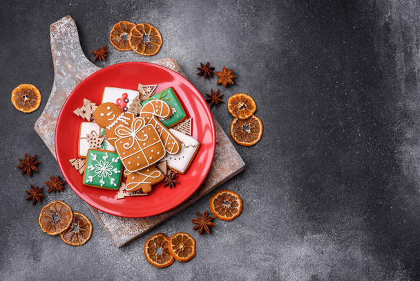 Beautiful delicious sweet winter Christmas gingerbread cookies on a gray textured background. Preparing for a family holiday - Photo, Image
