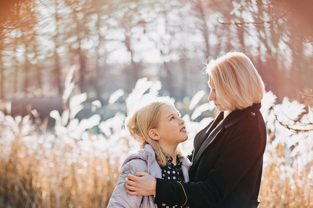 Moeder-Dochter relatie. Hoe vind ik Common Ground met tienerdochters. gelukkig tiener meisje wandelen en spelen met haar moeder in de herfst park - Foto, afbeelding