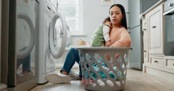 Žena drží dítě, prádelna a koš, nakládání oblečení v pračce a domácí práce. Matka, spící dítě a úklid, péče o děti a čištění oděvů s elektrickým spotřebičem. - Záběry, video