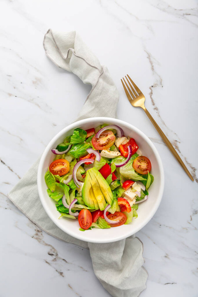 Salade verte saine avec avocat, tomates, mozzarella et oignons rouges - Photo, image