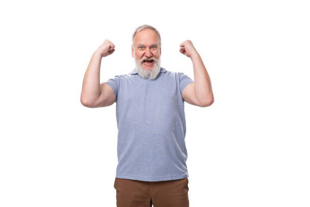 Tシャツに灰色のひげと口ひげが付いているハンサムな老人はエネルギーと健康でいっぱいです. - 写真・画像