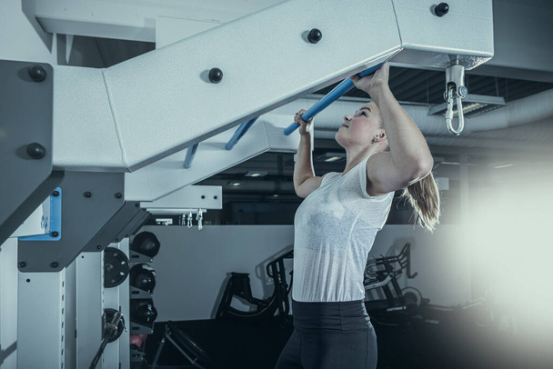 молодая женщина на чердаке тренировки в тренажерном зале или в тренажерном зале - Фото, изображение
