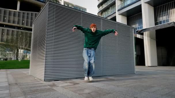 Dançando homem realizando vários freestyle dança ao ar livre na parede de rua se divertindo. Estilo de vida moderno, felicidade, breakdancing, dança hiphop, conceito de dança de rua - Filmagem, Vídeo