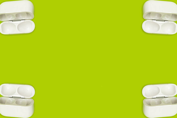 Collage grüne Farbe mit weißen drahtlosen Kopfhörern - Foto, Bild