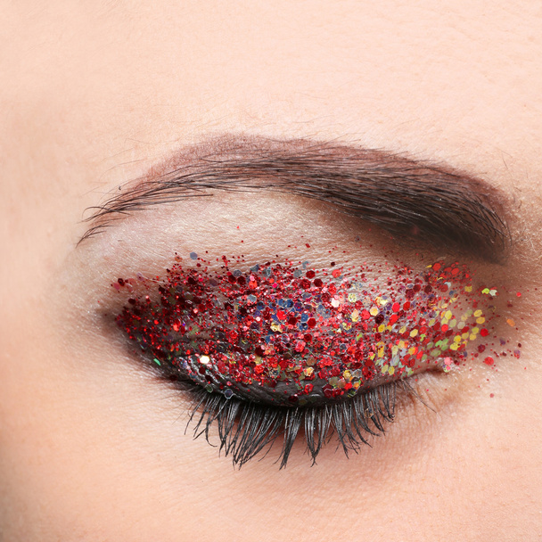 Female eye with fancy glitter makeup, macro view - Foto, afbeelding