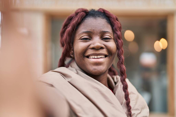 Afroamerykanka uśmiecha się pewnie robiąc selfie przed kamerą na ulicy - Zdjęcie, obraz
