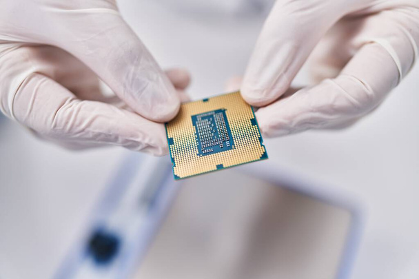 Giovane scienziato uomo ispanico in possesso di chip processore cpu in laboratorio - Foto, immagini