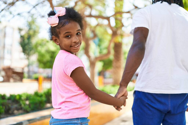 Otec a dcera usměvavá sebevědomá chůze s rukama u sebe v parku - Fotografie, Obrázek