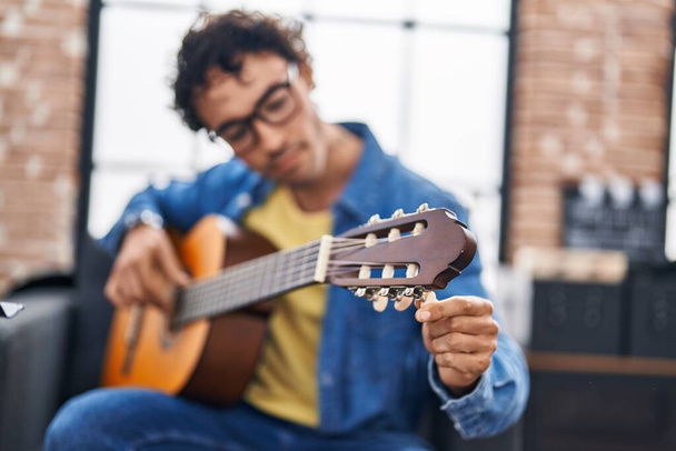 Νεαρός Ισπανός μουσικός που παίζει κλασική κιθάρα στο στούντιο μουσικής - Φωτογραφία, εικόνα