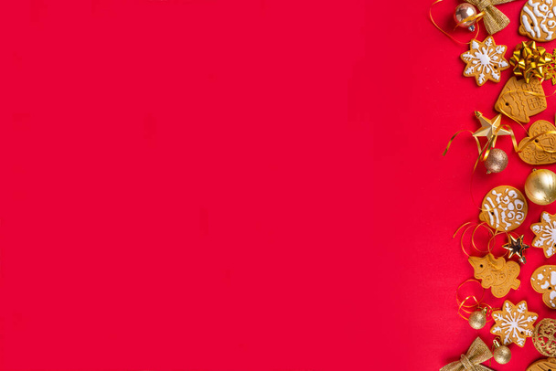 Weihnachten, Neujahrskekse, Lebkuchen mit goldenen Weihnachtsdekorationen und Christbaumkugeln auf rotem Hintergrund. Weihnachtsgrußkarte mit Lebkuchen von oben Ansicht kopieren Raum - Foto, Bild