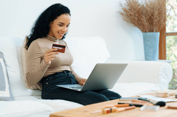 Nuori onnellinen nainen ostaa tuotteen online-ostoksia kotona, kun tilaat kohteita Internetistä luottokortilla online-maksujärjestelmä suojattu ratkaiseva cyber turvallisuus verkkokaupasta alustan - Valokuva, kuva