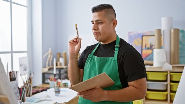 Komea latinotaiteilija piirtämässä taidestudioonsa, nuoren miehen matka luovuuteen ja oppimiseen - Valokuva, kuva