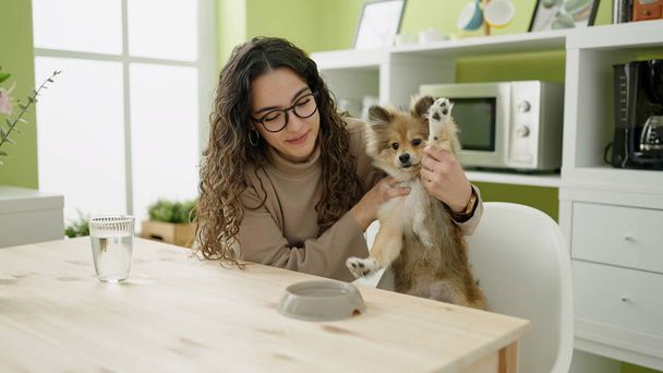 Nuori latino nainen koira istuu pöydällä juomaveden klo ruokasali - Valokuva, kuva