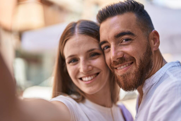 man en vrouw paar glimlachen zelfverzekerd maken selfie door camera op straat - Foto, afbeelding