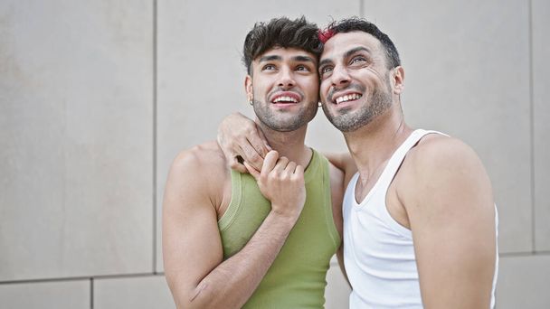 Due uomini coppia sorridente fiducioso abbracciarsi su sfondo bianco isolato - Foto, immagini