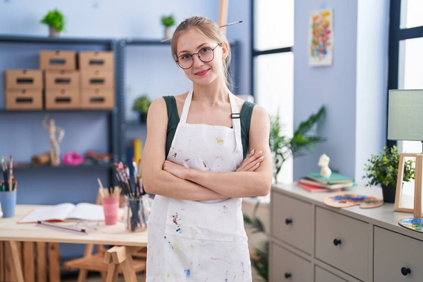 Young caucasian woman artist smiling confident standing with arms crossed gesture at art studio - Foto, Bild