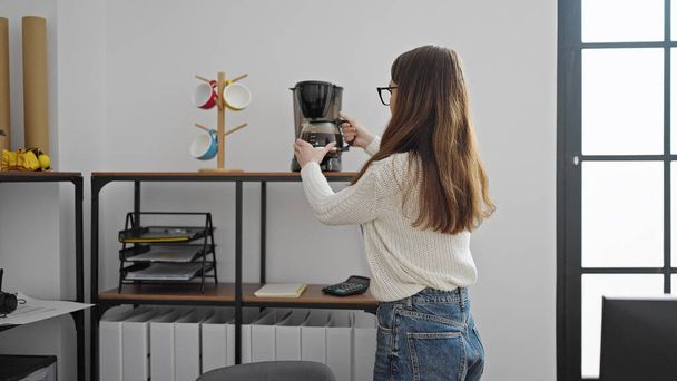 Jeune femme hispanique travailleuse d'affaires préparant le café au bureau - Photo, image