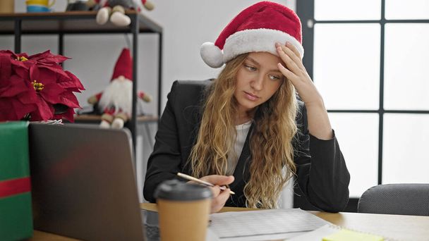 Mladá blondýna žena obchodní pracovník slaví Vánoce pracovní stres v kanceláři - Fotografie, Obrázek