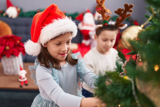 Adorable niño y niña decorando el árbol de Navidad en casa - Foto, Imagen