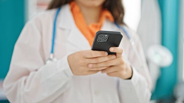 Joven hermosa mujer hispana médico usando smartphone en la clínica - Foto, imagen