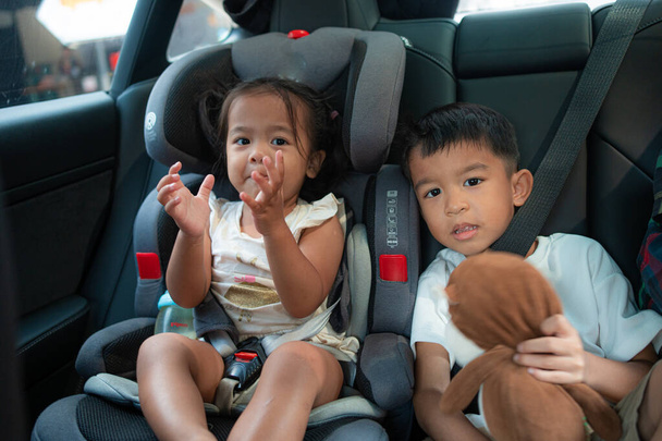 Kleines Kind Junge und Mädchen sitzen auf Carseta mit Sicherheitsgurt Reisekonzept - Foto, Bild