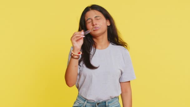 Exhausted tired Indian young woman takes off glasses, feels eyes pain, being overwork burnout from long hours working. Sleepy exhausted Arabian girl rubbing eyes isolated on studio yellow background - Footage, Video