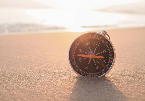 Закройте компас на пляже солнечным светом - Фото, изображение