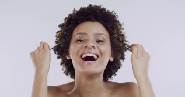 Haare, Schönheit und Gesicht einer glücklichen schwarzen Frau mit Selbstpflege im Studio und weißem Hintergrund. Natur-, Haar- und Personenporträt mit Selbstbewusstsein, Freude und Augenzwinkern für Hautpflege oder Salonkosmetik. - Filmmaterial, Video