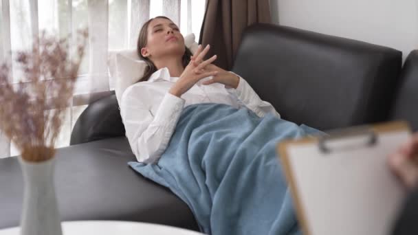 Çömelmiş yatmakta olan genç bir kadın hasta ofiste zihinsel tedavi sırasında travmatik bir olay, endişe ve akıl hastalığından psikiyatriste duygu salıyor. Psikolojik danışma seansı. Düzenle - Video, Çekim