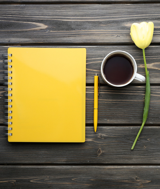 Notebook with cup of coffee and white tulip on wooden background - Foto, imagen
