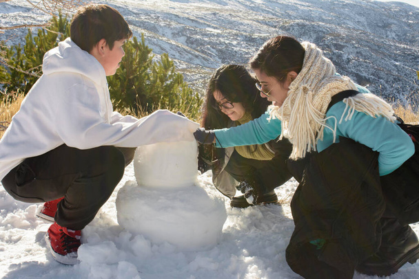 Snowy Escapades A Heartwarming Latino Family Building Snowman Memories in Sierra Nevada, - Photo, Image
