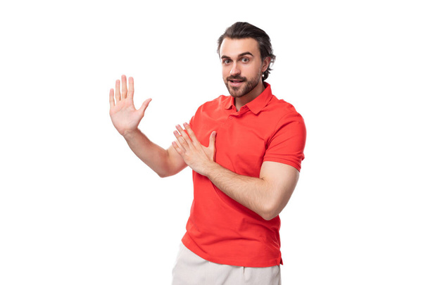 νεαρός βάναυση καυκάσιος μελαχρινή άνδρας με γενειάδα φορώντας t-shirt σκέφτεται επιχειρηματική στρατηγική στο φόντο στούντιο με αντίγραφο χώρο. - Φωτογραφία, εικόνα