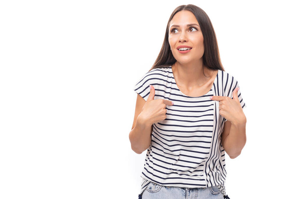 young positive pretty european brunette woman in a striped t-shirt on a white background with copy space. - Photo, Image