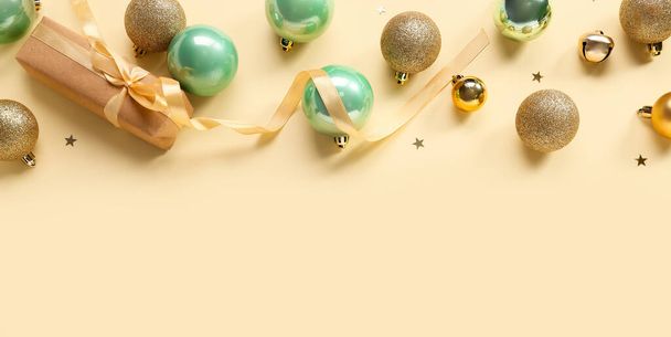 Kerstballen en geschenkdoos op gele achtergrond - Foto, afbeelding