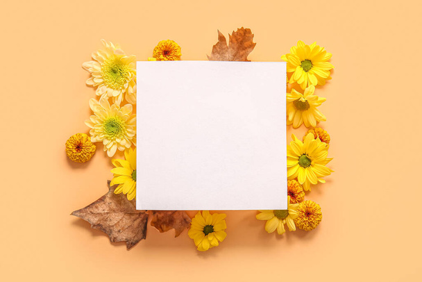 Порожня листівка з красивими квітами хризантеми та листям на помаранчевому фоні - Фото, зображення