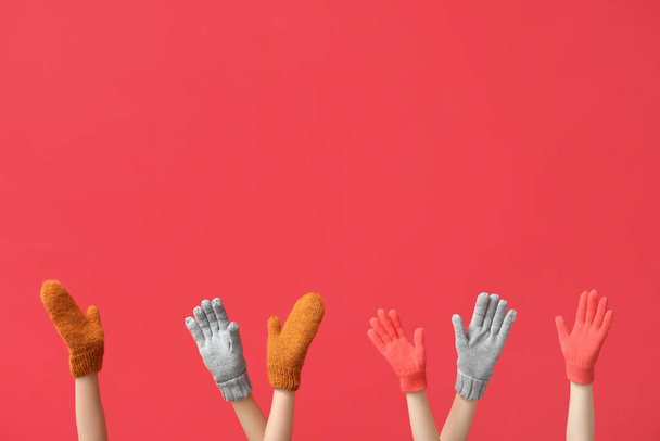 Mani femminili in guanti caldi e guanti su sfondo rosso - Foto, immagini