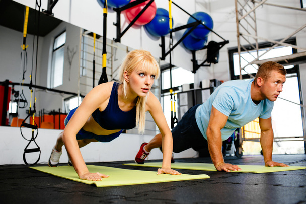 Woman doing pushups with trainer - Foto, afbeelding