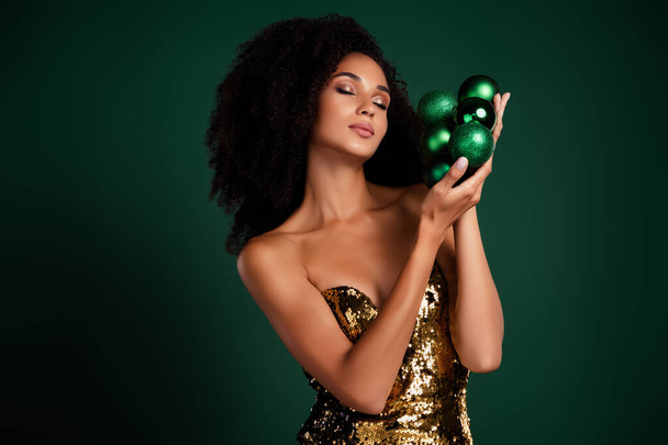 ゴージャスな女性の写真 丸いクリスマスツリーのおもちゃは緑の背景上のイベントのための理想的な装飾を宣伝します. - 写真・画像