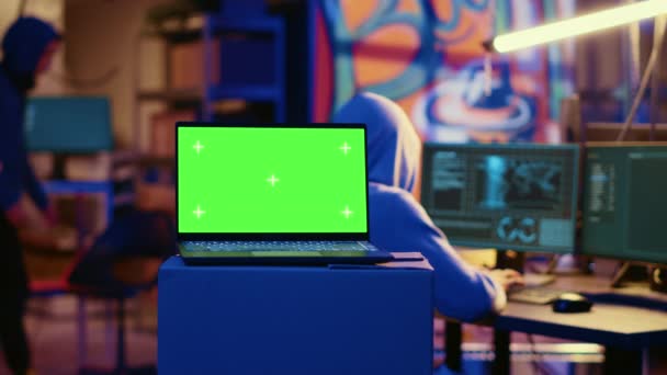 laptop tela verde em bunker com paredes de grafite deixadas para trás por hackers para agir como chamariz. Dispositivo Mockup executando script pinging local errado para aplicação da lei cibercriminal persegui-los - Filmagem, Vídeo