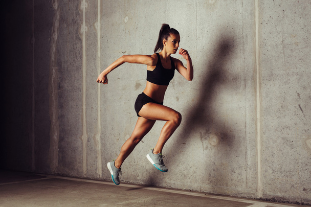 Attractive sportswoman running - Foto, afbeelding