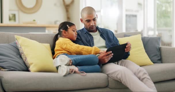 Tablet app, hry a táta se svou dcerou na pohovce v domácím obývacím pokoji pro vzdělávání nebo učení. Děti, podpora a motivace s otcem učí své dítě, zatímco sedí spolu. - Záběry, video