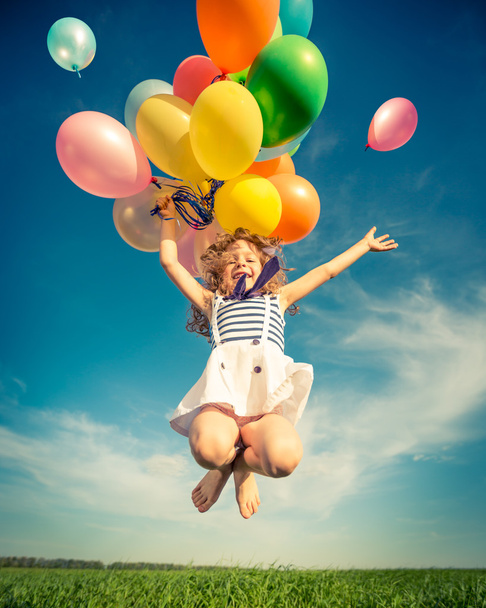 Child with toy balloons in spring field - Foto, imagen